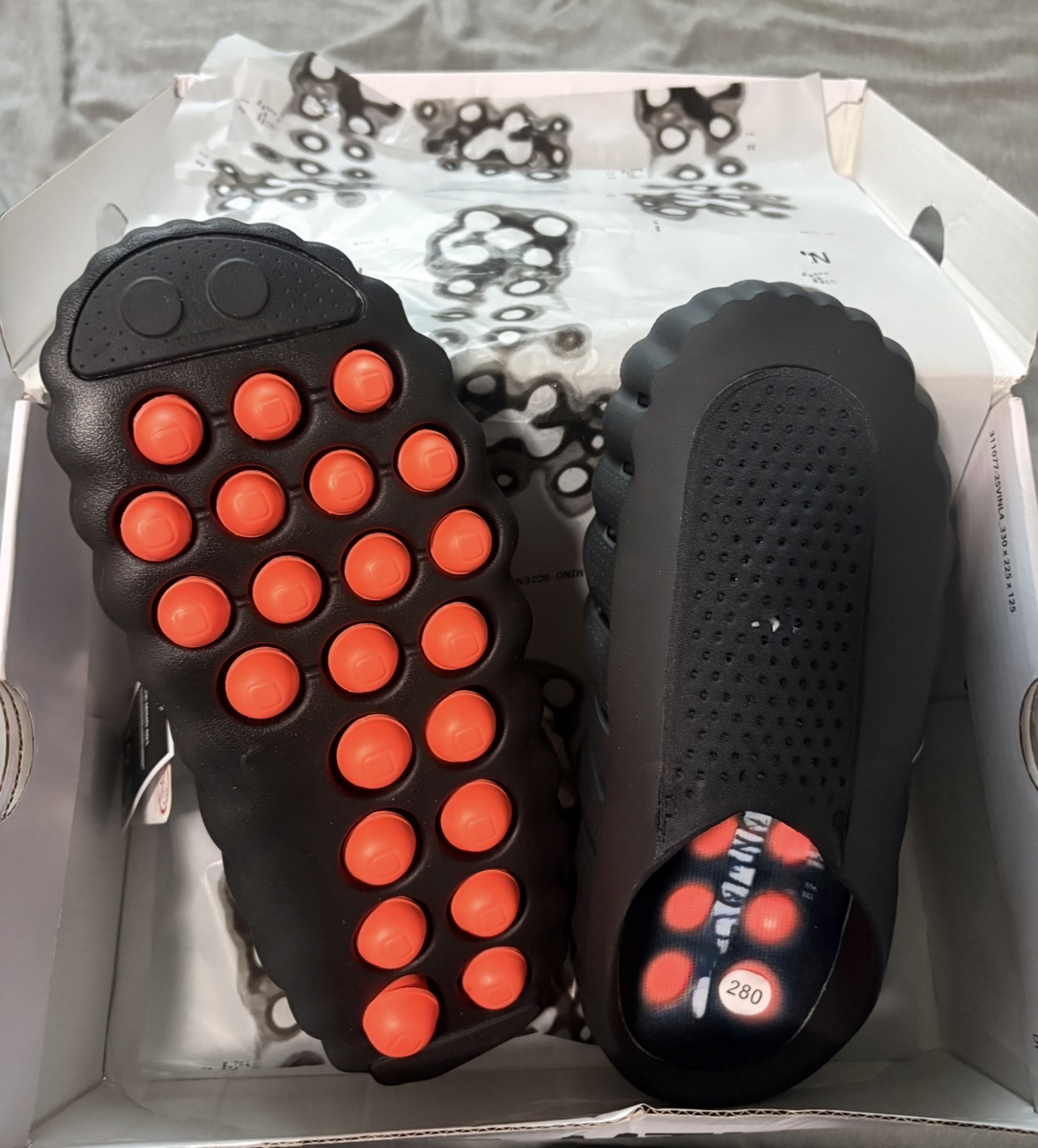 MIKE Mind 001 — sculpted black slides with red bubble outsole, premium designer-style footwear